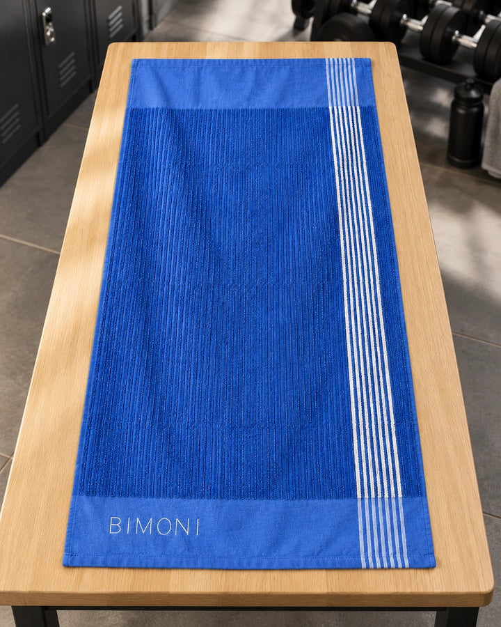 BIMONI serviette – Bleu – Posée à plat dans l’espace fitness