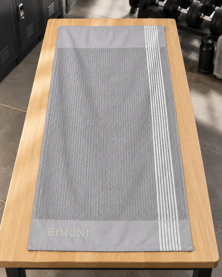 BIMONI serviette – Gris – Posée à plat dans l’espace fitness